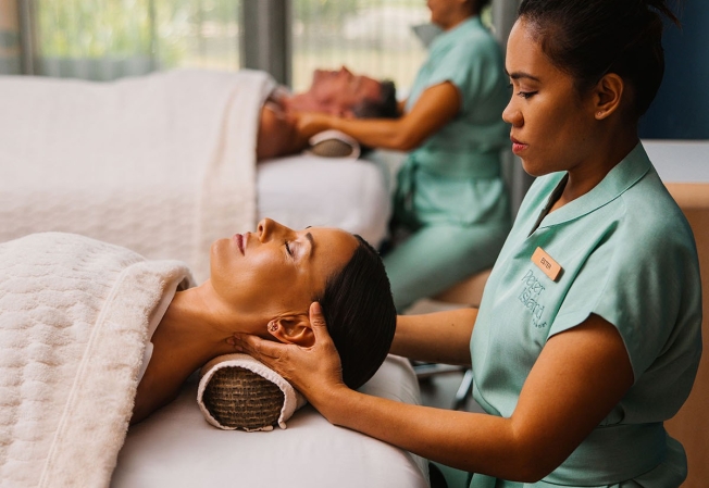 Two guests getting a neck massage with therapists massaging the back of their neck