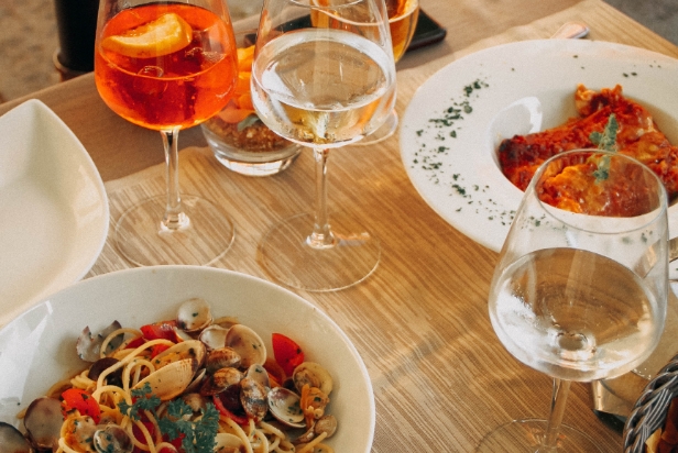 Image of table with wine glasses and food dishes with Dining text overlay.