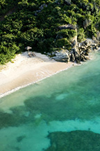 Aerial image of white sand beach and water.