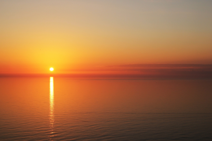 Image of a sunset over an ocean scene.